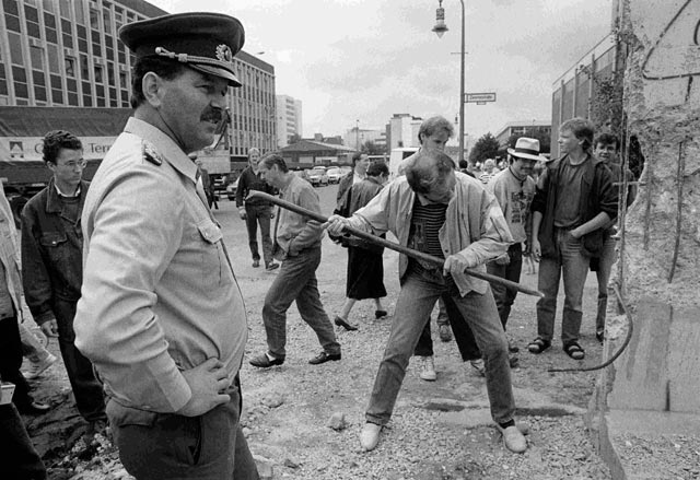muro-de-berlin-un-soldado-observa-como-un-hombre-golpea-el-muro-en-1990